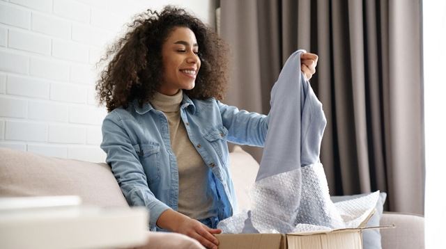 Woman pulling new clothing out of a delivered box